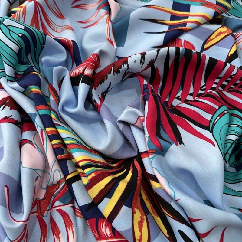 Tecido Viscose Estampada Folhagens Colorido Fundo Azul Claro • Luema